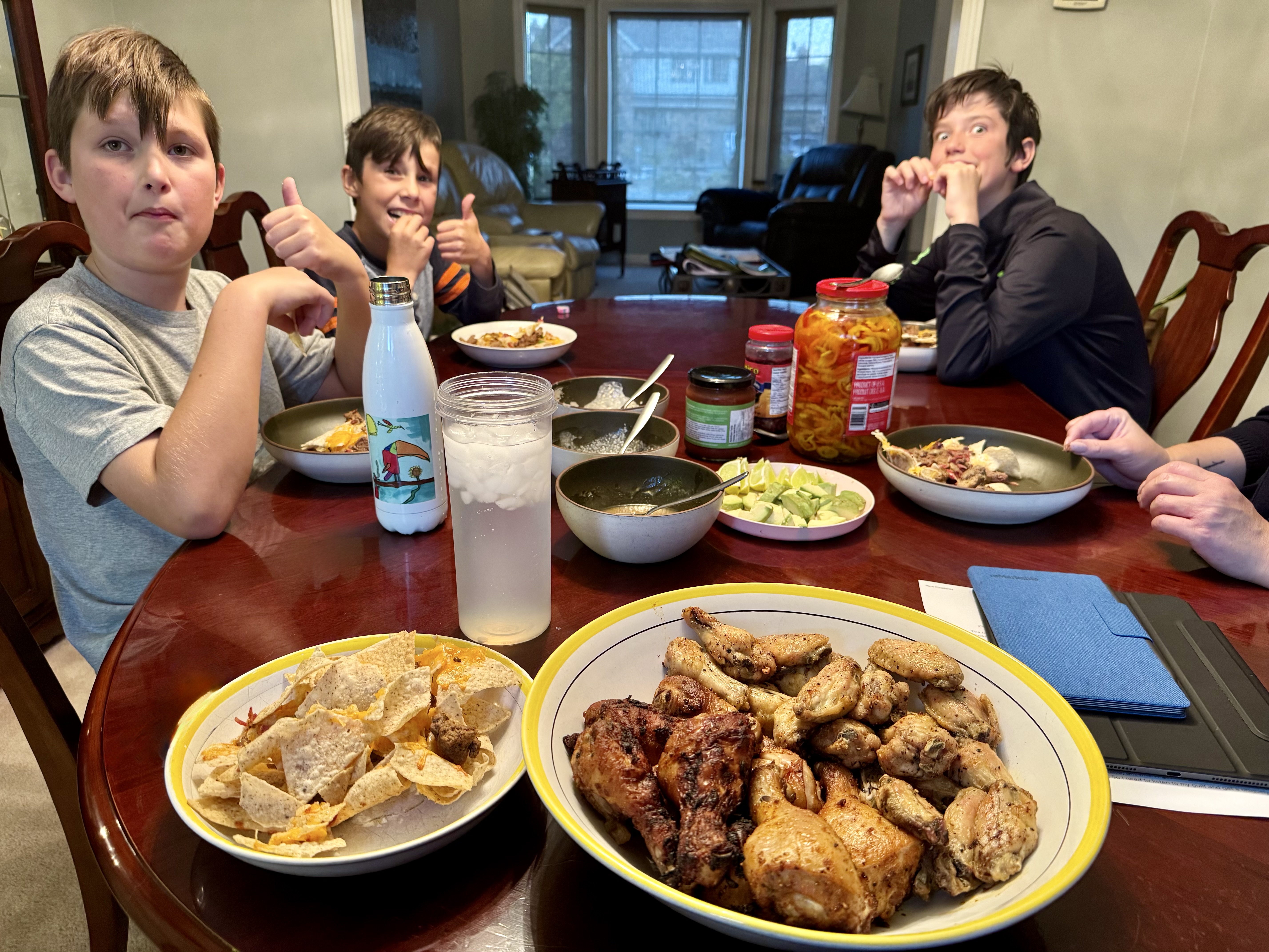 The boys excitedly waiting to dig into nachos and wings.